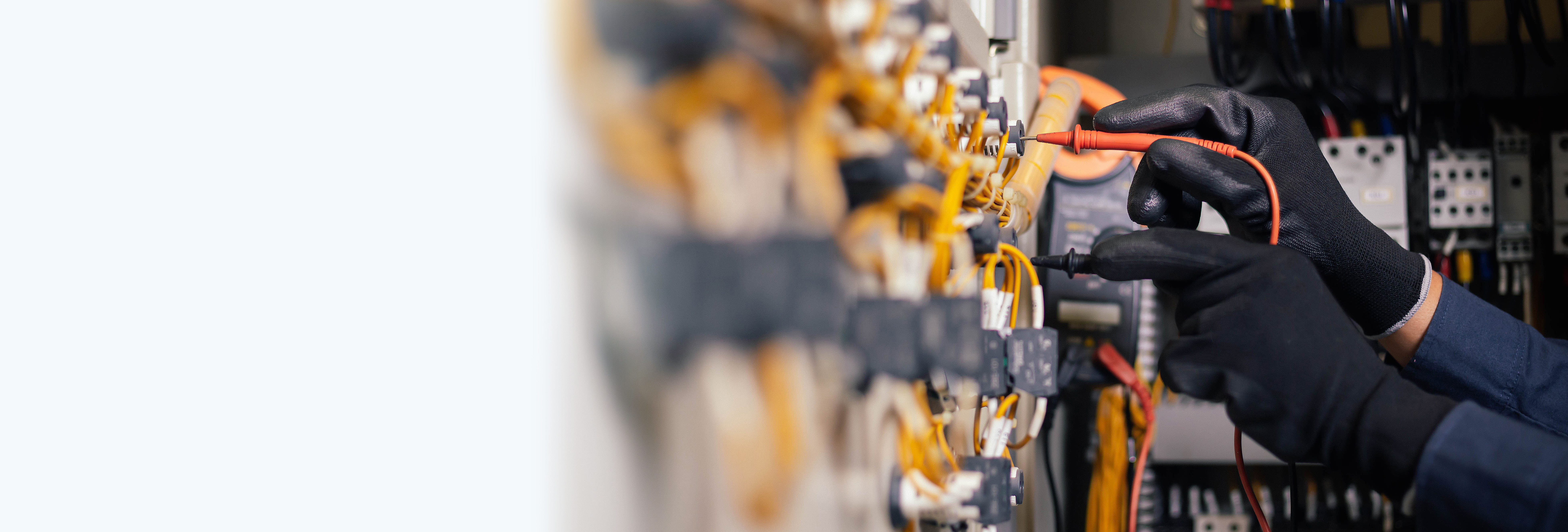 Electrician engineer work tester measuring voltage and current of power electric line in electical cabinet control.and wires on relay protection system. Bay control unit. Medium voltage switchgear.